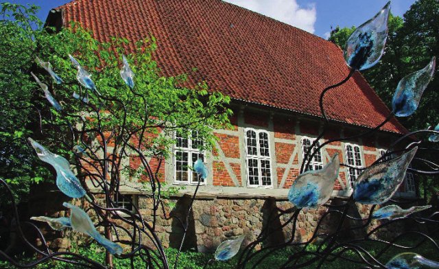 Schiff der Egestorfer Kirche mit künstlerischen Glasblumen im Vordergrund.